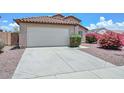 Exterior view of a home showcasing a two-car garage and well-maintained landscaping at 1527 S 219Th Ln, Buckeye, AZ 85326