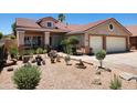 Single story home features desert landscaping in the front, as well as a tile roof and neutral colors at 1643 E Oakland St, Chandler, AZ 85225