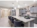 Stylish kitchen featuring granite countertops, stainless steel appliances, a breakfast bar, and pendant lighting at 18835 W San Miguel Ave, Litchfield Park, AZ 85340