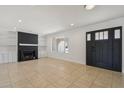 Bright living room with a brick fireplace, built-in shelving, and neutral tile floors at 2519 E Geneva Dr, Tempe, AZ 85282