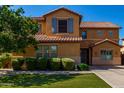 Inviting two-story home boasting a well-maintained lawn, mature shrubs, and desert-style tile roof at 3080 E Andre Ave, Gilbert, AZ 85298