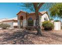 Well-manicured front yard of a single-story home featuring desert landscaping and a shade tree on a sunny day at 3550 E Topeka Dr, Phoenix, AZ 85050