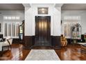 Elegant foyer with wood flooring, a dark front door, white walls and decorative furnishings at 42105 N Golf Crest Rd, Anthem, AZ 85086