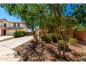 View of a two-story home's front exterior with desert landscaping, and a long driveway at 42616 W Avella Dr, Maricopa, AZ 85138