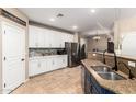 Well-lit kitchen features white cabinets, stainless steel appliances, and granite countertops at 42616 W Avella Dr, Maricopa, AZ 85138