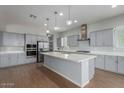 Modern kitchen with stainless steel appliances, gray cabinets and a large kitchen island at 5139 N 185Th Ave, Litchfield Park, AZ 85340