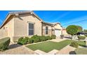 Beautiful home exterior boasting rock accents, mature shrubs, and a well-manicured lawn at 5316 N 186Th Dr, Litchfield Park, AZ 85340