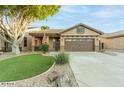 Charming single-story home with a well-manicured lawn, desert landscaping, and a two-car garage at 7027 W Blackhawk Dr, Glendale, AZ 85308
