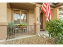 Inviting front porch with a decorative railing, cozy seating, and a well-manicured landscape at 7027 W Blackhawk Dr, Glendale, AZ 85308