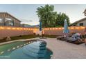 Outdoor pool area featuring a covered patio, lounge chairs, and ambient string lights, ideal for entertaining at 7027 W Blackhawk Dr, Glendale, AZ 85308