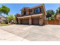 Two-story home with a three-car garage, stone accents, wide driveway, and well-maintained landscaping at 723 E Gemini Pl, Chandler, AZ 85249
