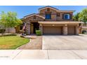 Charming two-story home with a well-kept lawn, stone accents, and a spacious three-car garage at 723 E Gemini Pl, Chandler, AZ 85249