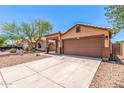 Charming single-story home with desert landscaping, a two-car garage, and a covered entry at 7419 W Raymond St, Phoenix, AZ 85043