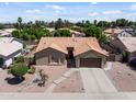 Inviting single-story home featuring desert landscaping, a two-car garage, and a well-maintained tile roof at 7736 W Tumblewood Dr, Peoria, AZ 85382
