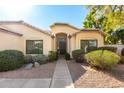 Inviting front entrance with a stylish door, desert landscaping, and an arched entryway at 780 W Morelos Ct, Chandler, AZ 85225