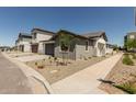 Charming home features low maintenance desert landscaping and a gray two-car garage at 9416 E Sequence Ave, Mesa, AZ 85212