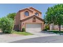 Two-story home with a front garage and lush green lawn with foliage at 111 N Soho Pl, Chandler, AZ 85225