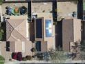 Aerial view of a home with solar panels, tidy backyard, and red cars in the driveway at 11936 W Charter Oak Rd, El Mirage, AZ 85335