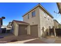 Spacious two-car garage with brick-paved driveway and well-kept landscaping, set under a clear blue sky at 14861 W Ashland Ave, Goodyear, AZ 85395
