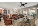 Cozy living room with comfortable seating, ceiling fan, and large windows at 15532 W Prairie Dunes Dr, Surprise, AZ 85374