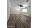Well-lit living space showcasing new flooring, a ceiling fan, and a large window at 1627 W Pueblo Ave, Mesa, AZ 85202