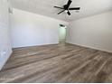 Spacious living room with modern plank flooring, a ceiling fan, and freshly painted white walls at 1627 W Pueblo Ave, Mesa, AZ 85202