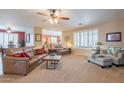 Bright living room with plush carpeting, plantation shutters, and comfortable seating at 16781 W Northampton Rd, Surprise, AZ 85374