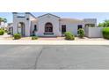 Charming home featuring a stucco exterior, arched entryway, and a well-maintained front yard at 16803 N 49Th Way, Scottsdale, AZ 85254