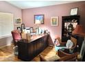 Traditional home office featuring a large wooden desk, hardwood floors, and soft ambient lighting at 17257 W Papago St, Goodyear, AZ 85338