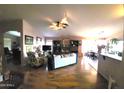 Open-concept living room boasts hardwood floors, a ceiling fan, and an entertainment center at 17257 W Papago St, Goodyear, AZ 85338