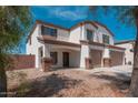 Exterior angle of a two-story home with tan stucco and a gravel yard at 22966 W Hopi St, Buckeye, AZ 85326