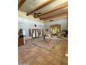 Open living room showcasing beamed ceilings, Saltillo tile floors, and a flood of natural light at 25449 W Pueblo Ave, Buckeye, AZ 85326