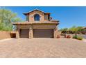 This home features a two-car garage, brick-paved driveway, desert landscaping and a charming gate at 3030 N Saranac --, Mesa, AZ 85207