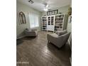 Cozy seating area with wood-look tile flooring and a built-in bookshelf creates a relaxing atmosphere at 30394 N Appalachian Trl, San Tan Valley, AZ 85143