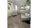 Cozy seating area with wood-look tile flooring and picture gallery wall creates a relaxing atmosphere at 30394 N Appalachian Trl, San Tan Valley, AZ 85143