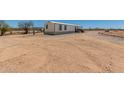 Single-story mobile home with a small porch, set against a desert landscape under a clear sky at 48773 Cerezo Rd # 20, Maricopa, AZ 85139
