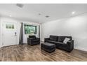Cozy living room featuring wood-look floors, sofa, chair and large window at 5709 S 13Th Ave, Phoenix, AZ 85041