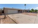 Spacious driveway leading to a one-story home with a garage and minimalist landscaping at 5807 W Encanto Blvd, Phoenix, AZ 85035