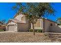 Two-story home featuring a tan stucco exterior and low-maintenance desert landscaping at 640 W Country Estates Ave, Gilbert, AZ 85233