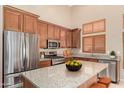 Modern kitchen with stainless steel appliances, granite countertops, and custom wood cabinets at 6936 E Snowdon St, Mesa, AZ 85207
