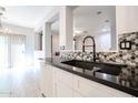 Modern kitchen featuring dark countertops, white cabinets, and mosaic backsplash at 813 E Agua Fria Ln, Avondale, AZ 85323