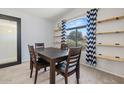 Inviting dining area with a dark wood table, and minimalist wooden shelving at 878 E Mountain View Rd, San Tan Valley, AZ 85143