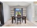 Bright dining room with a vaulted ceiling, modern shelves, and a large arched window at 878 E Mountain View Rd, San Tan Valley, AZ 85143