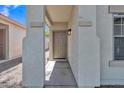 Covered entryway with neutral columns and a solid wood front door at 9261 W Sheridan St, Phoenix, AZ 85037