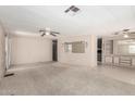 Bright living room with carpet flooring, ceiling fan and built in shelving at 9347 E Edgewood Ave, Mesa, AZ 85208
