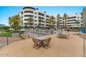 A shaded common area with a table and chairs next to a pool and lounge seating at 945 E Playa Del Norte Dr # 1016, Tempe, AZ 85288