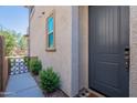 Close-up of a neutral gray front door with a modern digital lock and landscaped walkway at 1055 W Diamondback Dr, Chandler, AZ 85286