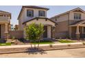 Charming two-story home featuring a cozy front porch with stone accents and a well-manicured front yard at 13465 N 158Th Ave, Surprise, AZ 85379