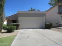 Spacious driveway leading to a two-car garage with well-maintained landscaping at 1450 E Laurel Ave, Gilbert, AZ 85234