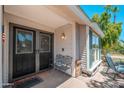 Inviting front porch with seating area, a pair of leaded glass doors, and neutral siding at 14622 N 45Th Pl, Phoenix, AZ 85032